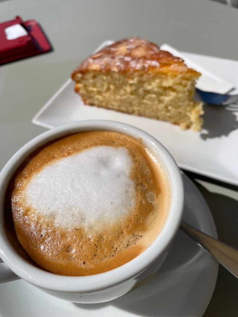 Mallorcan almond cake and cafe con leche served in a beachfront cafe in Port de Soller.